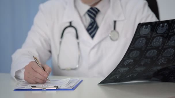 Radiologista descrevendo cuidadosamente a ressonância magnética do cérebro dos pacientes, ponderando diagnóstico — Vídeo de Stock