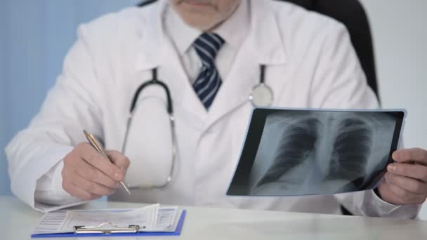 Pulmonólogo examinando la radiografía de los pulmones y prescribiendo tratamiento al paciente — Vídeos de Stock