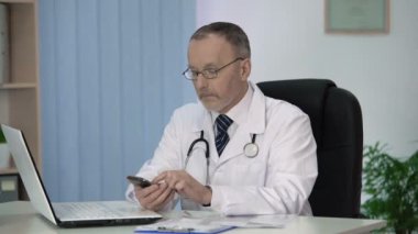 Doktor onun smartphone cep telefonu ile özel uygulamada tıbbi referans kitabı okuma
