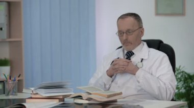 Araştırma çalışmaları için konu hakkında kitap yığın düşünme önünde oturan doktor