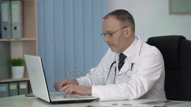 Yorgun terapist elektronik kayıt dosyalarında hasta muayene sonrasında doldurma