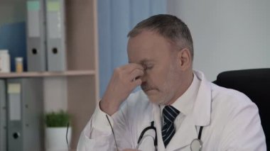 Onun pratikte oluştu tıbbi durumlar hakkında düşünmek yorgun erkek doktor