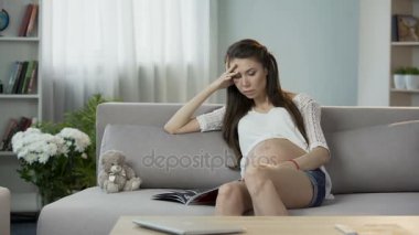 Genç hamile kadın oturma kanepe, okuma dergisi, dinlendirici boş zaman