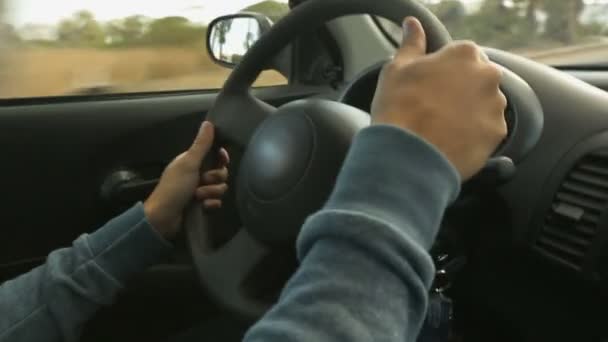 Mani maschili uomo saldamente tenendo volante di auto in giro per la città — Video Stock