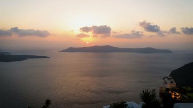 Santorini Island, Yunanistan etrafında sakin deniz üzerinde nefes kesen turuncu günbatımı manzarası