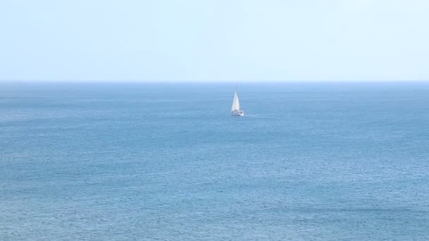 Barco solitario blanqueamiento contra el fondo increíble de la superficie del mar azul sin fin — Vídeos de Stock