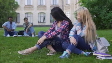 Çocuklar seyir ve flört, college yakınındaki Çimenlikte oturan gençler kız öğrenciler