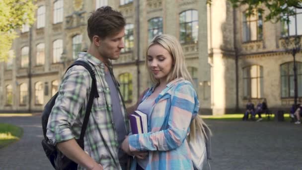 Stilig ung man flirta med vackra blonda nära college, studenter, möte — Stockvideo