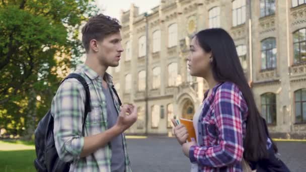 Mnohonárodnostní studentů diskutovat o testování poblíž kampusu, samec a samice mluví — Stock video