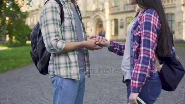 Joven acariciando la mano de la novia tiernamente, amor estudiantil, relación — Vídeo de stock