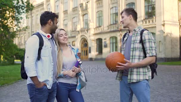 Jovem conversando com casal multirracial perto da faculdade, vida estudantil despreocupada — Vídeo de Stock