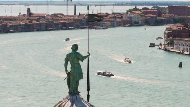 Широкое водное пространство с катерами между рядами зданий, мужская статуя спереди — стоковое видео