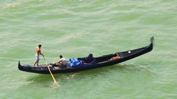 Wenecja, Włochy - około czerwca 2016: Zwiedzanie miasta. Niedoświadczony przewoźnik praktykujący do wiersza gondola z starsze gondolier u jego boku — Wideo stockowe