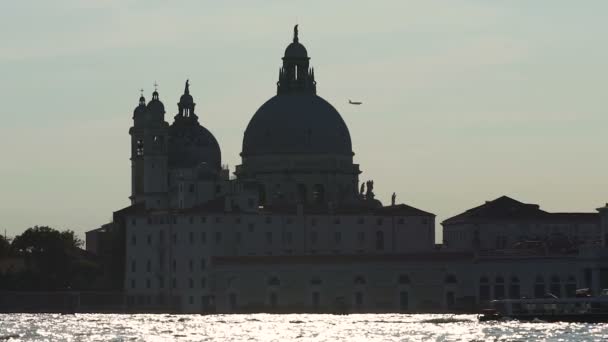 Avión volando sobre iglesia situada a orillas del Gran Canal iluminado por el sol, Venecia, Italia — Vídeo de stock