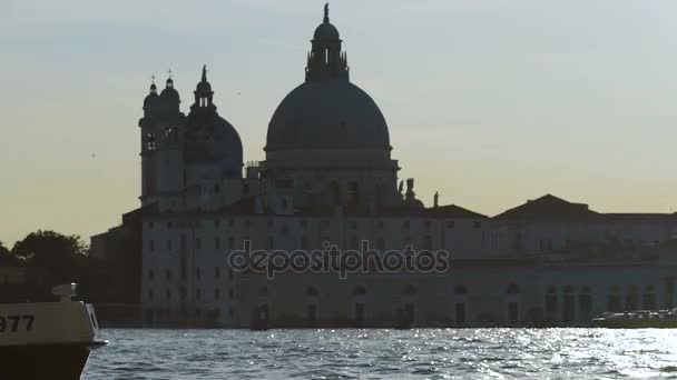 Venedig, Italien, Circa juni 2016: Sightseeing i staden. Människor som går längs vattnet, motorbåt förbi kyrkan över floden — Stockvideo