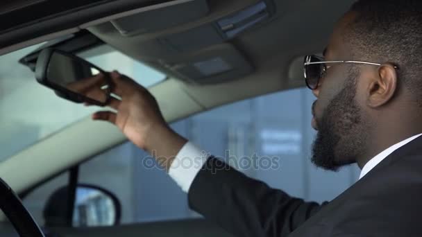 Αρσενικό κάθεται στο αυτοκίνητο και να ψάχνει στο κάτοπτρο οδηγήσεως, σοβαρές διαπραγματεύσεις, μαφία — Αρχείο Βίντεο
