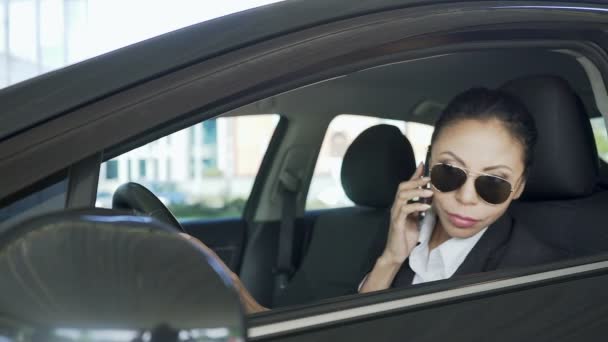 Mulher sentada no carro e falando no telefone celular, sombreamento, detetive particular — Vídeo de Stock