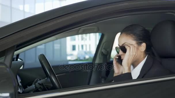 Señora en gafas de sol, sentado en el coche y hablando por teléfono celular, agente de policía — Vídeo de stock