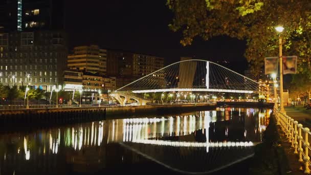 Night view at arch footbridge across Nervion River in Bilbao, Spain, timelapse — Stock Video