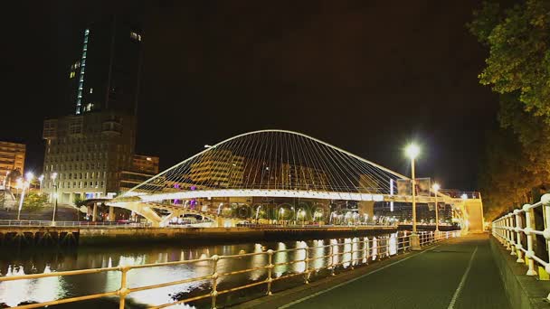 Personas caminando en el puente de cristal iluminado Zubizuri por la noche, lapso de tiempo — Vídeo de stock