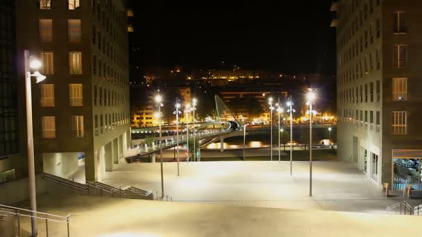 Vista de la construcción de vidrio de la pasarela de Zubizuri desde uno de los bancos, timelapse — Vídeos de Stock