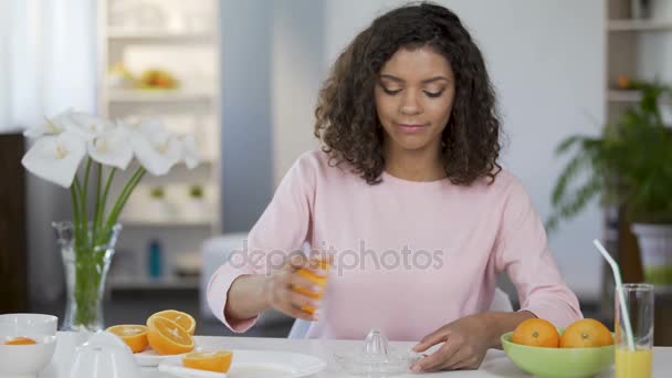 Raça mista jovem espremendo suco de laranja, peso e controle de saúde — Vídeo de Stock