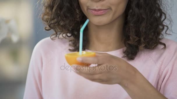 半分オレンジ色の健康管理、栄養ジュースを飲む民族の女性 — ストック動画