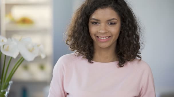 Multietniskt ung kvinna erbjuder apple, ler mot kameran, hälsosam livsstil — Stockvideo