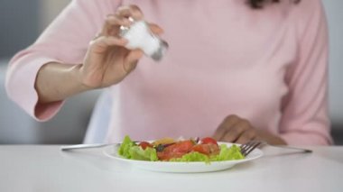 Kadın çok fazla tuz ekleyerek onun yiyecek, sağlıksız beslenme, su kaybı sorunları için