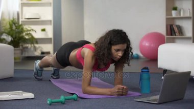 Dizüstü bilgisayar önünde Online egzersiz yapıyorsun, egzersiz karışık yarış genç kadın