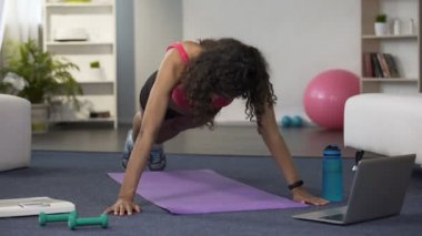 Kadın şınav ve online iş evde izlerken kaslar, germe