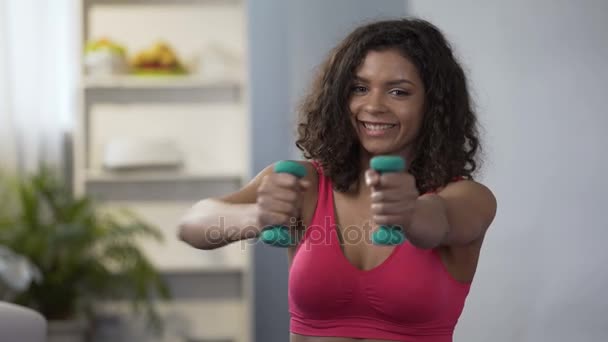 Mischlingsfrau, die zu Hause mit Kurzhanteln trainiert, gesunder Lebensstil, Fitness — Stockvideo