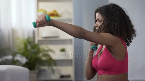 Sportliches Mädchen macht Boxbewegungen mit Hanteln in den Händen, Workout, Fitness — Stockvideo