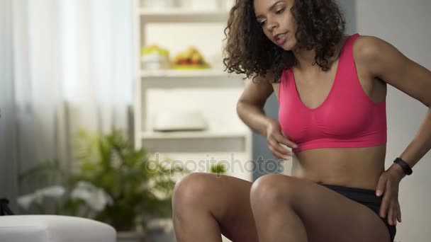 Смешанная расовая женщина растягивает спину после физических упражнений, боль в мышцах — стоковое видео
