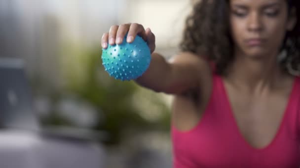 Mixed-Race-Frau drückt Ball in der Hand, trainiert Arme, Muskelkraft — Stockvideo