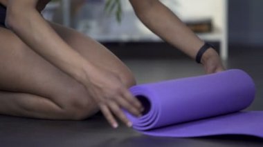 Yere diz çökmüş ve haddeleme yoga mat, boş zaman, etkin hobi uygun kız