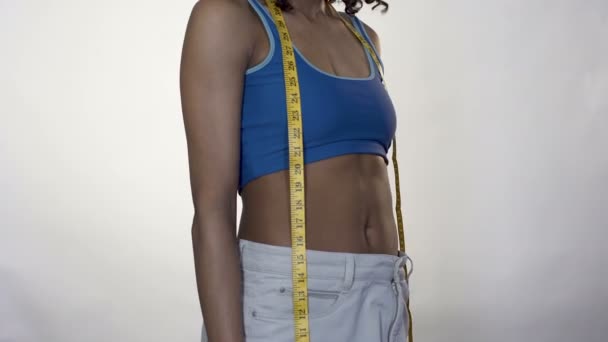 Молодая женщина показывает результаты потери веса, держа яблоко, контроль веса — стоковое видео