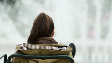 Çeşme önünde oturan ve zor iş günü sonra yalnızlık rahatlatıcı kadın