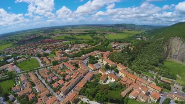 Spannende landschap van Italiaanse dorp liggen in de buurt van met gras begroeide heuvel onder de blauwe hemel — Stockvideo