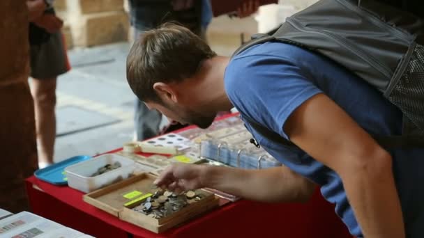 Turista mirando a través de monedas en caja de madera en la mesa en el mercado callejero, viajes — Vídeo de stock