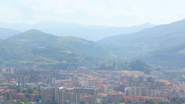 Gran ciudad con muchos edificios en el fondo de montañas verdes, Bilbao, vista aérea — Vídeos de Stock