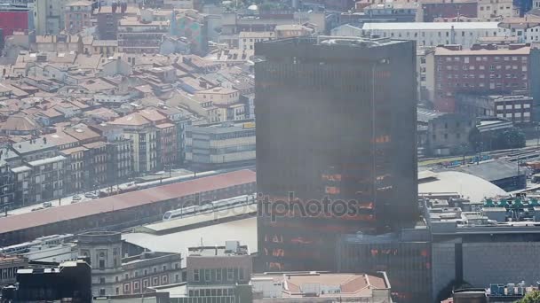 Glas kantoorgebouw stijgt boven de daken van de stad huizen, moderne stedelijke weergave — Stockvideo