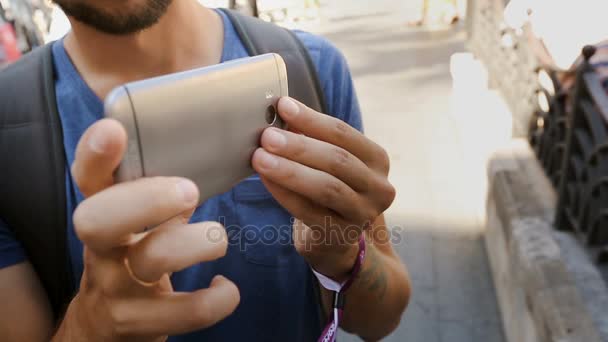 Turista masculino concentrado en tomar vídeo con el teléfono móvil en la plaza, primer plano — Vídeo de stock