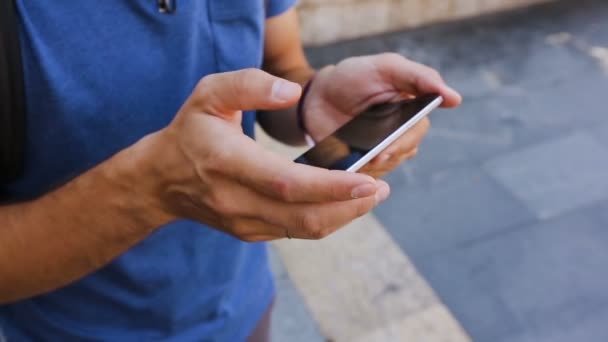 Jeune homme lisant des informations sur la vue célèbre sur son téléphone portable, gros plan — Video