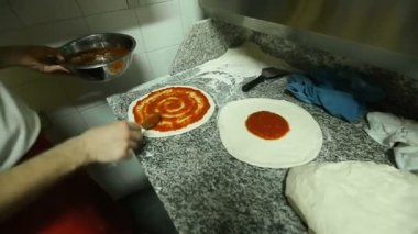 Şef ustaca pizza kabuk özel hazırlanan geleneksel sos ile bulaşması