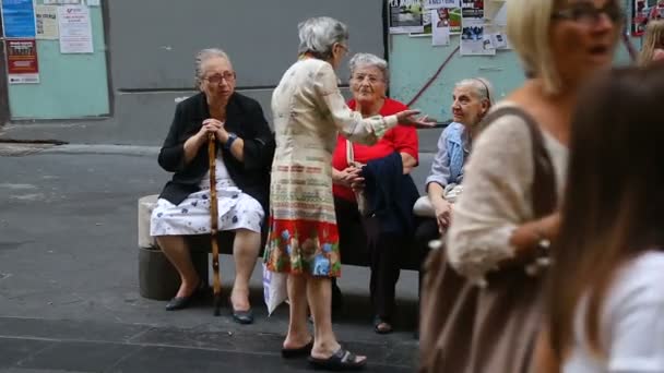 NAPLES, ITALIA - CIRCA JULIO 2014: Turismo en la ciudad. Mujeres mayores discutiendo problemas en el banquillo, beneficios del seguro de jubilación — Vídeos de Stock