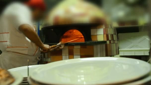 Chef cutting mouthwatering pizza in kitchen, serving it to restaurant guests — Stock Video