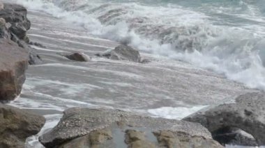 Kayalar, doğa, güç ile kumlu Sahili üzerinde haddeleme köpüklü okyanus dalgalarının uyuşuk