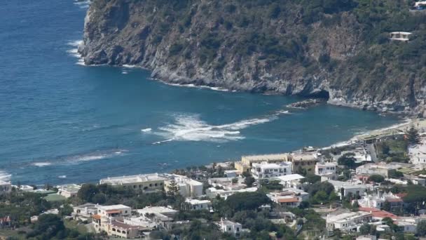 Blaue Bucht Wasser wälzt sich über Wellenbrecher, Ischia Insel Küste mit vielen Häusern — Stockvideo