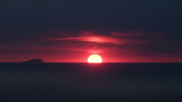 Ciel rouge foncé brûlant avec le soleil se cachant au-dessus de l'horizon, l'obscurité tombe, coucher de soleil — Video